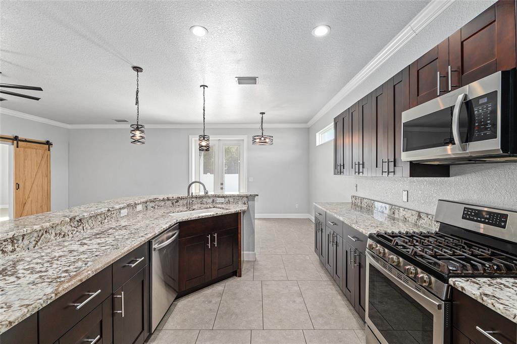 4765 Southeast 25th Street Ocala, FL 34480 - Photo 22 of 65 a kitchen with stainless steel appliances granite countertop a stove and a sink
