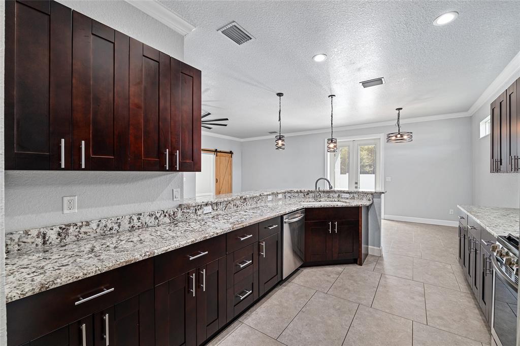 4765 Southeast 25th Street Ocala, FL 34480 - Photo 23 of 65 a large kitchen with granite countertop a sink and dishwasher