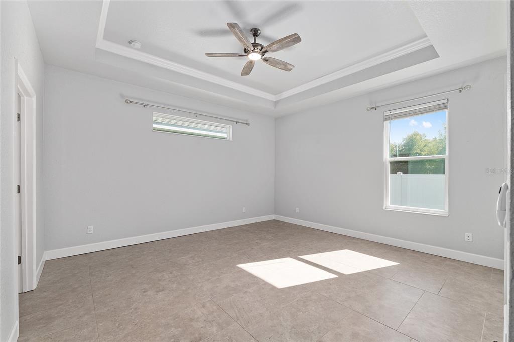 4765 Southeast 25th Street Ocala, FL 34480 - Photo 29 of 65 an empty room with windows and ceiling fan