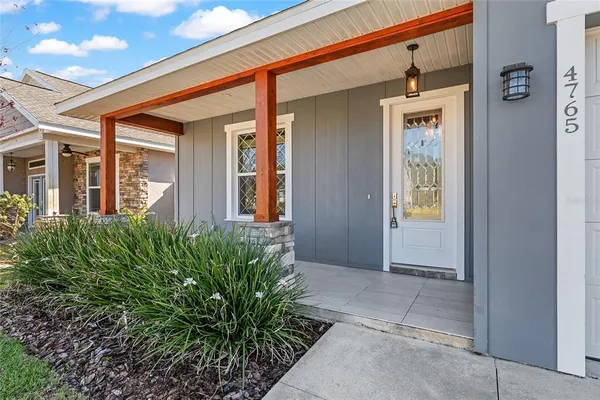 a porch with a bench next to a yard