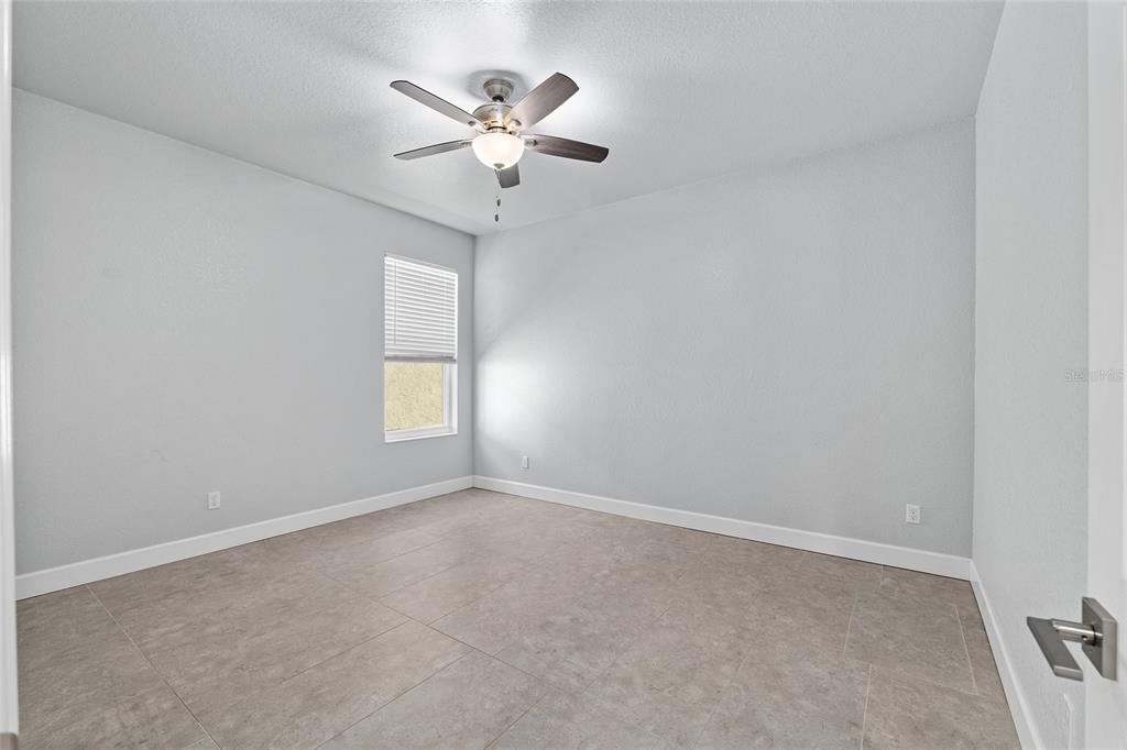 4765 Southeast 25th Street Ocala, FL 34480 - Photo 35 of 62 an empty room with a chandelier fan and windows