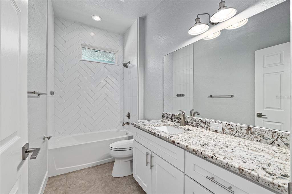 4765 Southeast 25th Street Ocala, FL 34480 - Photo 41 of 65 a bathroom with a granite countertop sink a toilet and shower