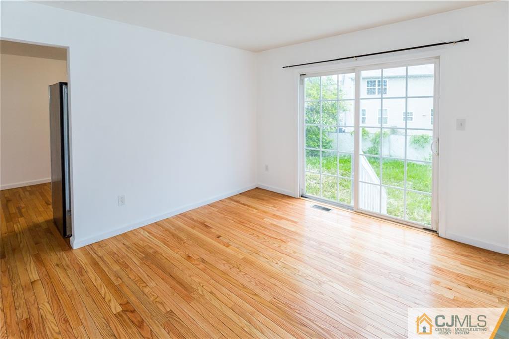 987 Cox Road North Brunswick, NJ 08902 - Photo 7 of 25 a view of an empty room with wooden floor and a window