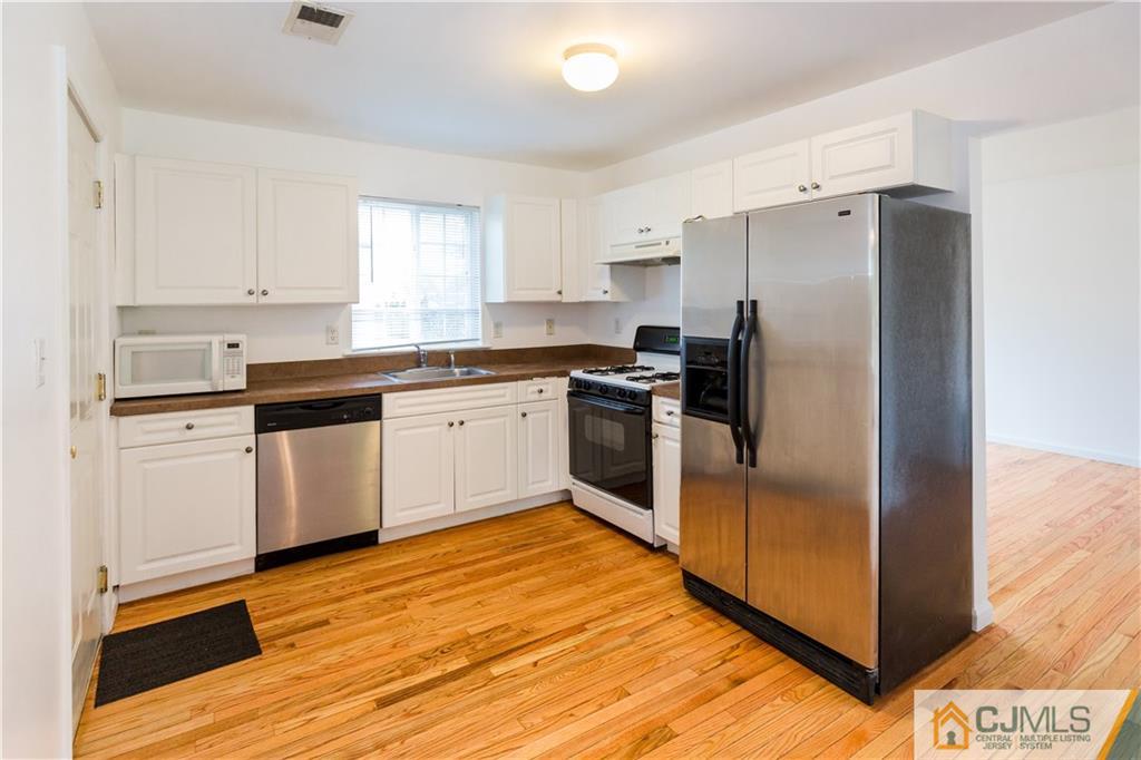 987 Cox Road North Brunswick, NJ 08902 - Photo 8 of 25 a kitchen with stainless steel appliances granite countertop a refrigerator sink and cabinets