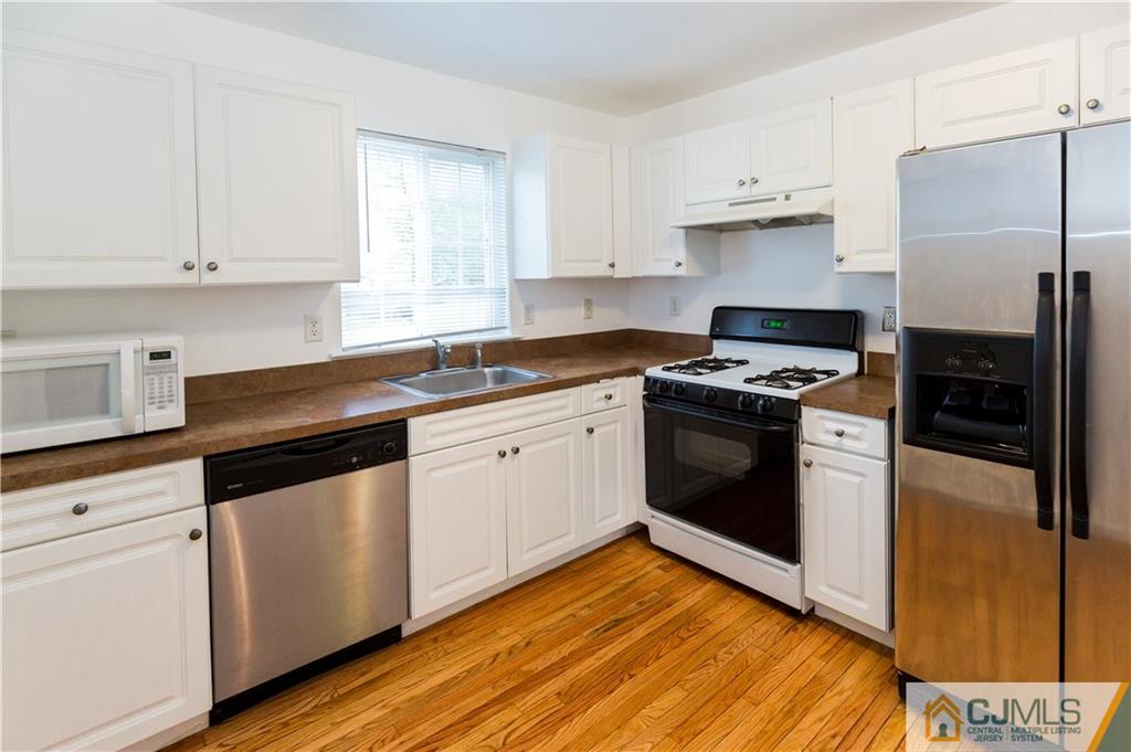 987 Cox Road North Brunswick, NJ 08902 - Photo 9 of 25 a kitchen with granite countertop white cabinets and white appliances