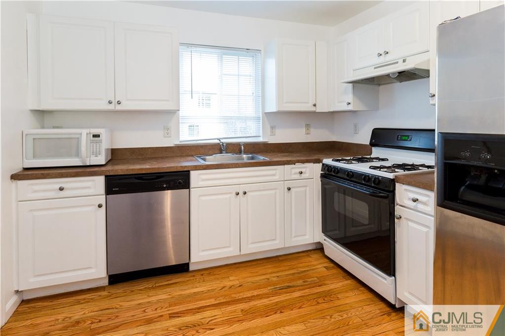 987 Cox Road North Brunswick, NJ 08902 - Photo 10 of 25 a kitchen with white cabinets and white appliances