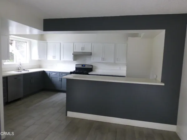 a kitchen with granite countertop white cabinets and black appliances