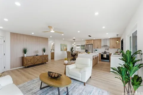 a living room with furniture kitchen view and a potted plant