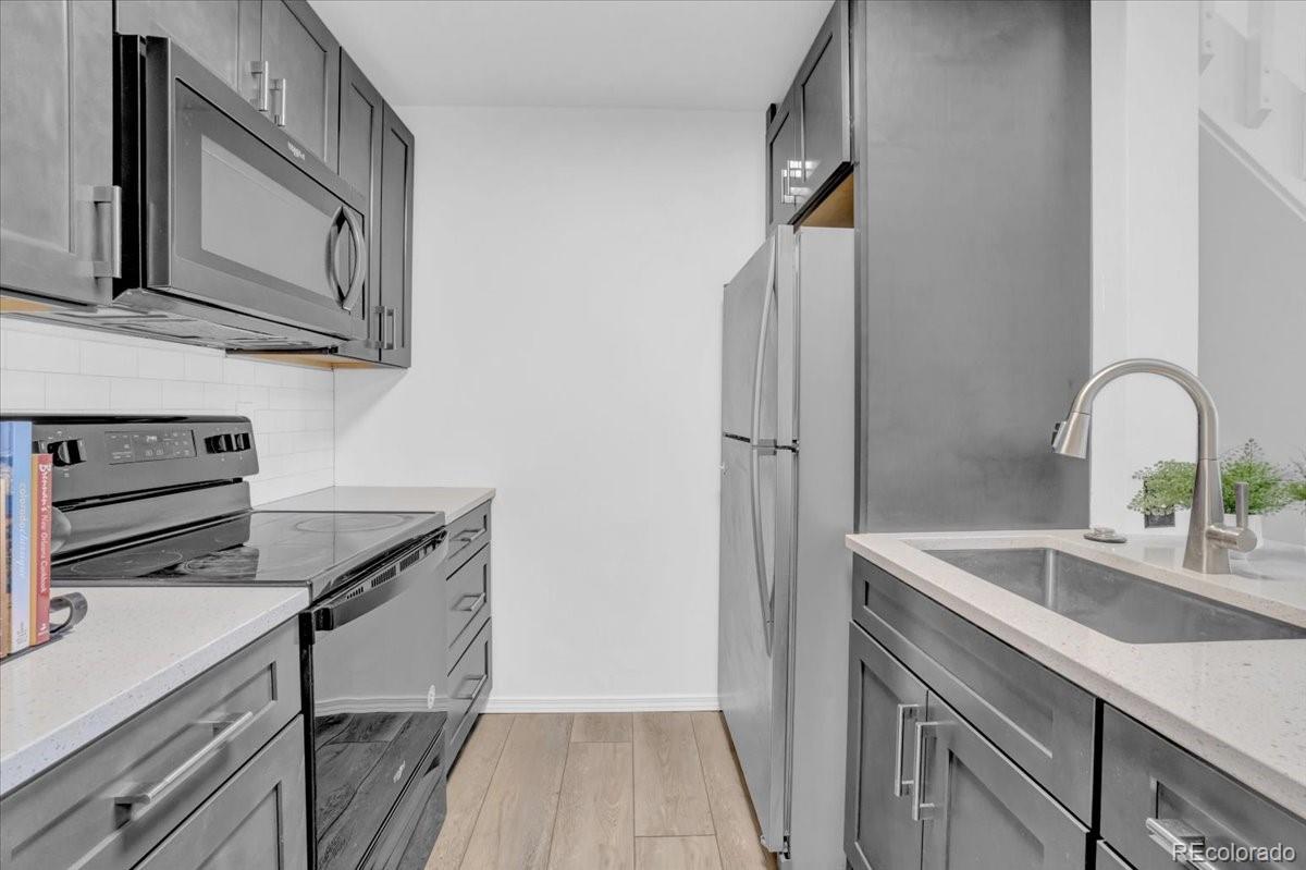 3066 West Prentice Avenue, Unit G Littleton, CO 80123 - Photo 4 of 18 a kitchen with stainless steel appliances granite countertop a sink and a stove top oven