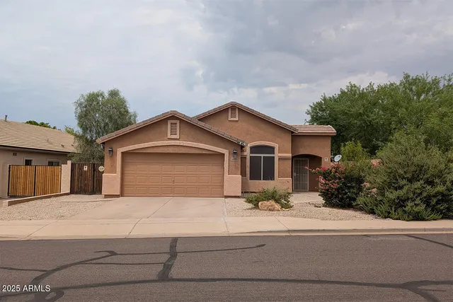 a front view of a house with yard and trees in the background