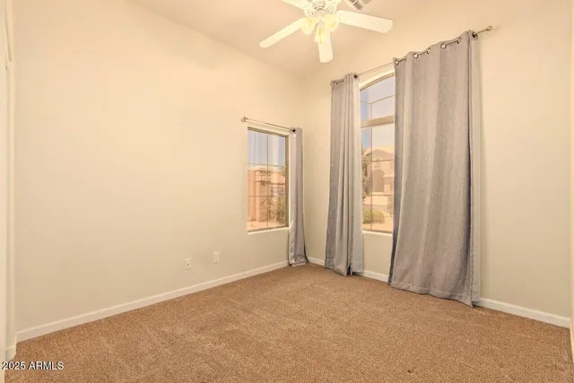 an empty room with a window and a ceiling fan