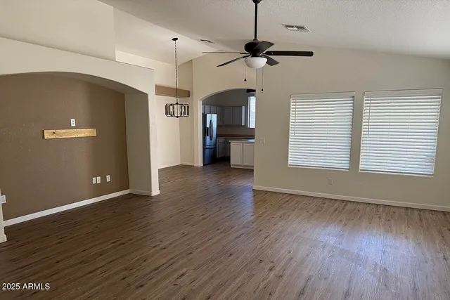 a view of a livingroom with a ceiling fan window and wooden floor