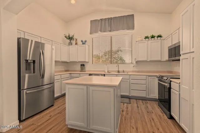 a kitchen with a refrigerator sink and cabinets