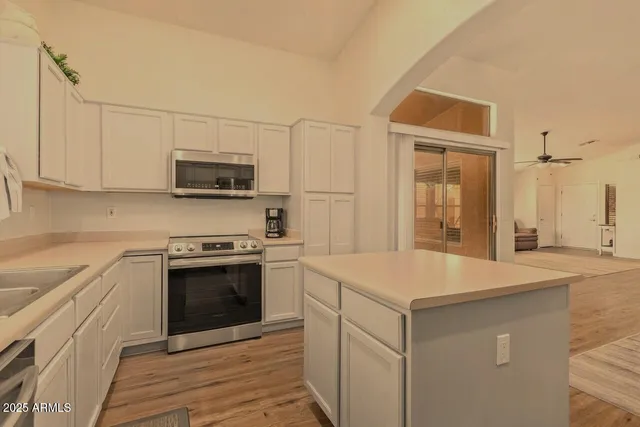 a kitchen with stainless steel appliances granite countertop a sink and a stove