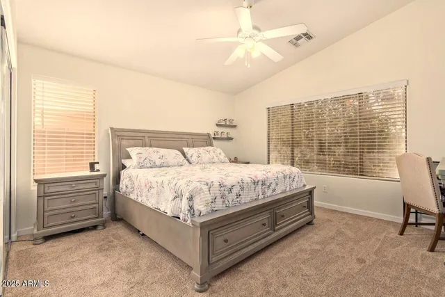 a bed sitting in a spacious bedroom next to a window