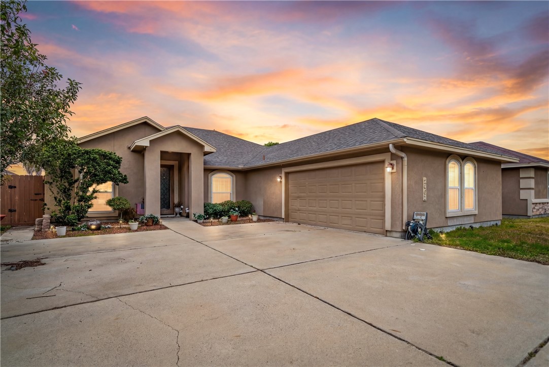 a front view of a house with yard and parking