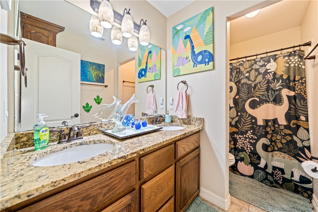 2602 Retta Drive Corpus Christi, TX 78418 - Photo 25 of 32 a bathroom with a granite countertop sink and a mirror