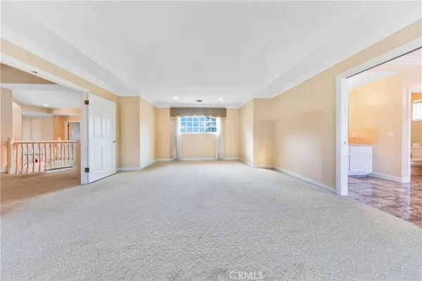 an empty room with chandelier fan and windows