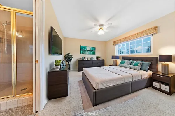 a bedroom with a large bed a chandelier and dresser