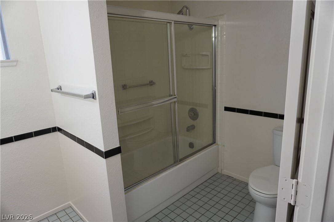 8328 Del Rey Avenue Las Vegas, NV 89117 - Photo 28 of 38 A well-maintained bathroom with a combination shower and tub, enclosed by sliding glass doors.