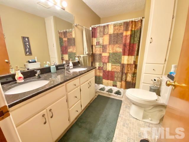 7008 Blalock Road Bahama, NC 27503 - Photo 7 of 15 a bathroom with a double vanity sink toilet and shower
