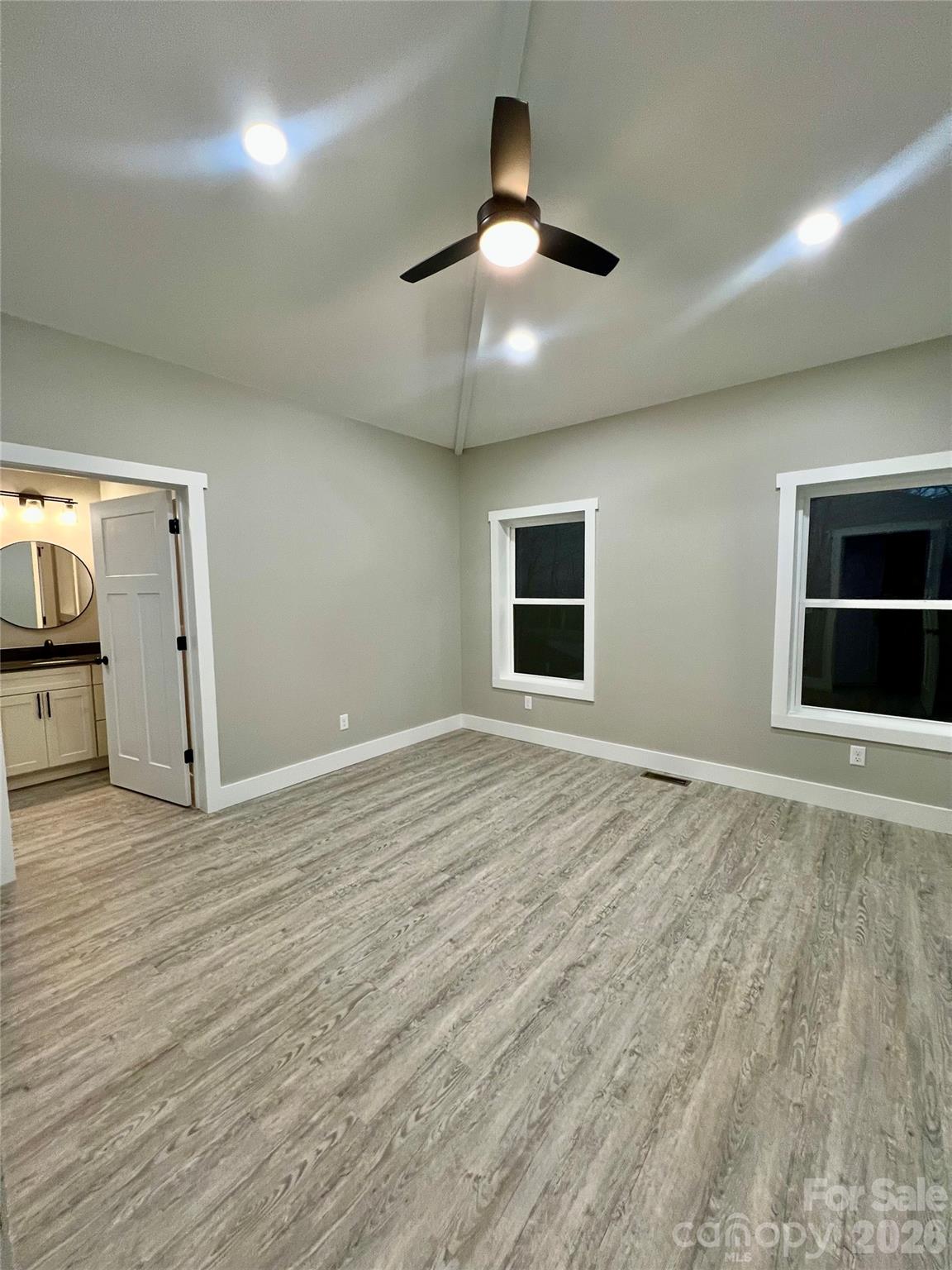 199 Clinchfield Gap Road Marion, NC 28752 - Photo 20 of 29 an empty room with chandelier fan and windows