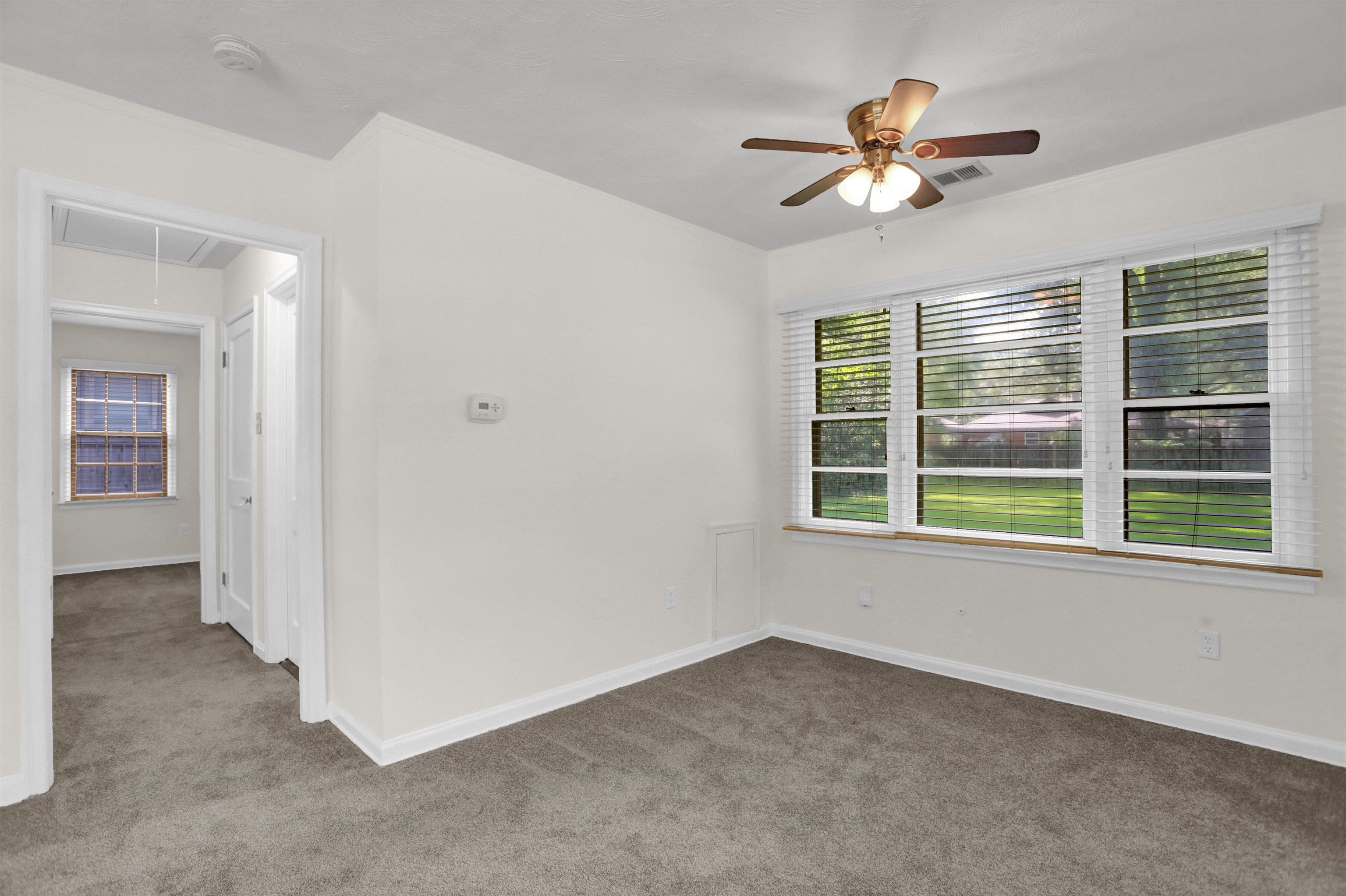 4545 Flamingo Road Memphis, TN 38117 - Photo 3 of 34 Room featuring a large window with white blinds, grey carpet, ceiling fan with light fixture, and white painted walls