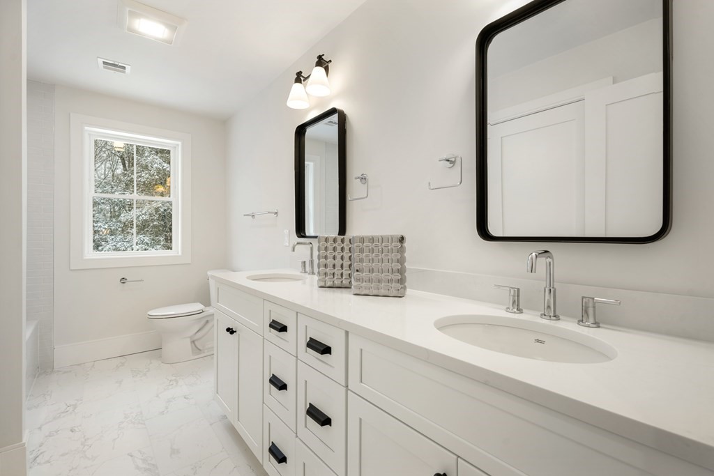 15 Peterson Road Natick, MA 01760 - Photo 13 of 27 a bathroom with a double vanity sink a toilet and a mirror