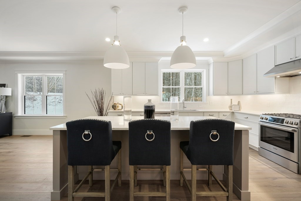 15 Peterson Road Natick, MA 01760 - Photo 3 of 27 a kitchen with a stove a sink a dining table and chairs