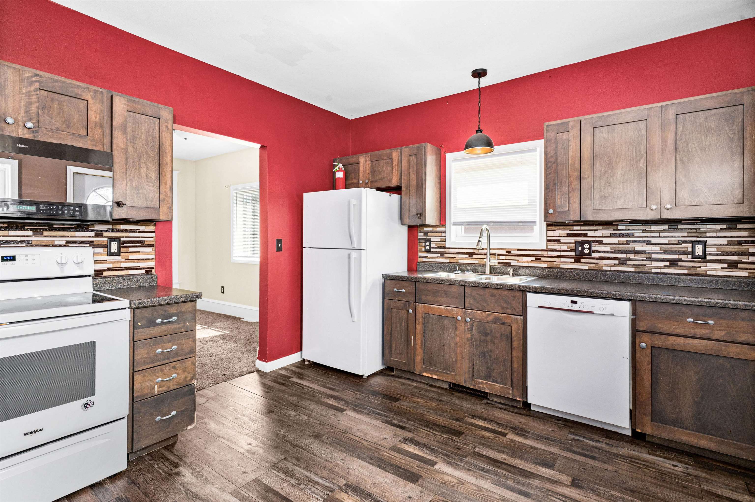4022 East 2nd Street Superior, WI 54880 - Photo 4 of 30 Kitchen with decorative backsplash, white appliances, dark countertops, and hanging light fixtures