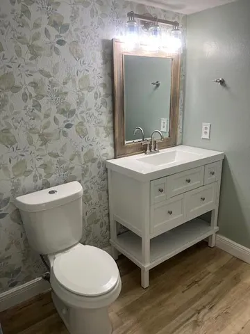 a bathroom with a toilet sink and mirror