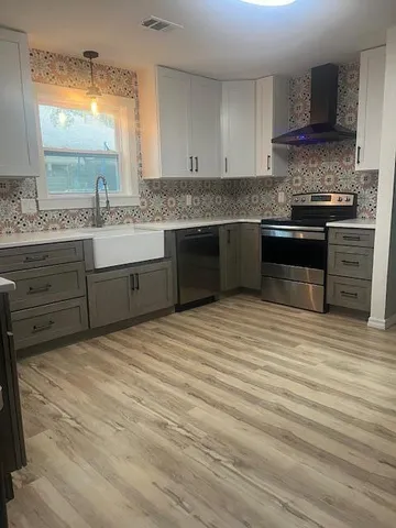 a kitchen with stainless steel appliances granite countertop a sink and a stove
