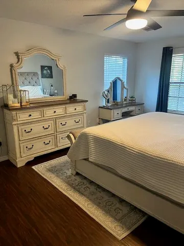a bedroom with a bed and a dresser with mirror