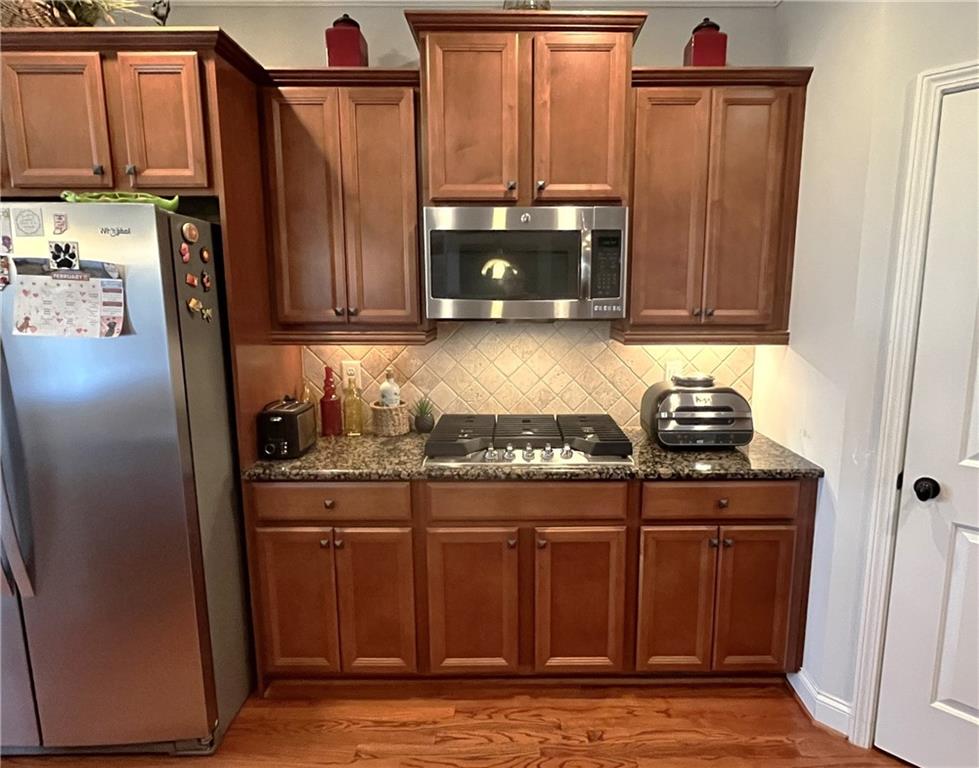 307 Cornerstone Trace Woodstock, GA 30188 - Photo 9 of 43 a kitchen with stainless steel appliances granite countertop a refrigerator and a stove