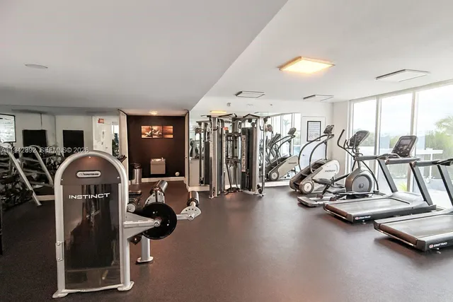a white kitchen with kitchen island a sink and wooden floor