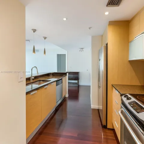 a view of a livingroom with wooden floor and a large window