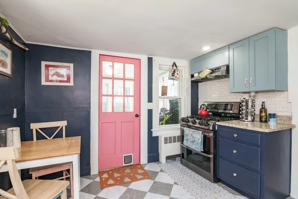a kitchen with stainless steel appliances a stove a sink cabinets and a window