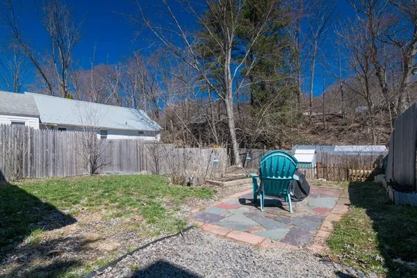a view of a backyard with chairs potted plants and wooden fence