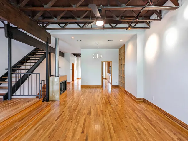 a view of an empty room with wooden floor