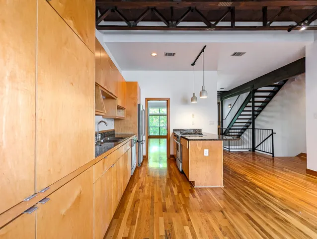 a kitchen with stainless steel appliances granite countertop a sink a stove and refrigerator