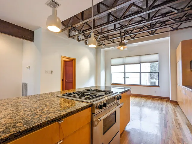 a kitchen that has a stove and a wooden floor