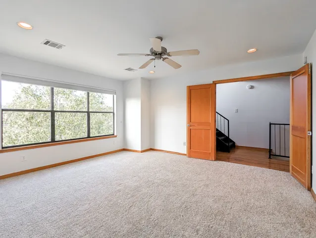 an empty room with a ceiling fan and a window