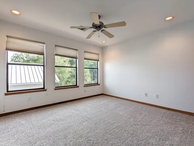 an empty room with a window and a ceiling fan