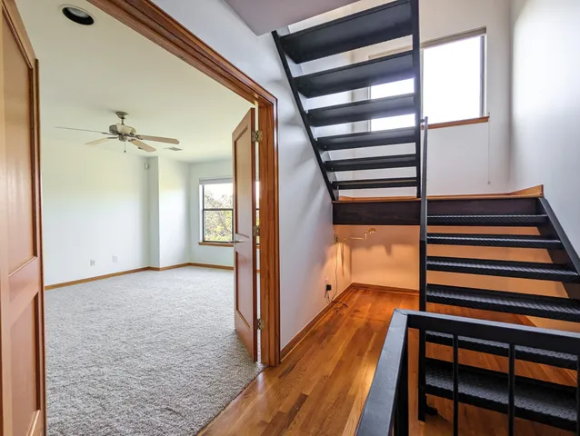 a view of a hallway with wooden floor and staircase