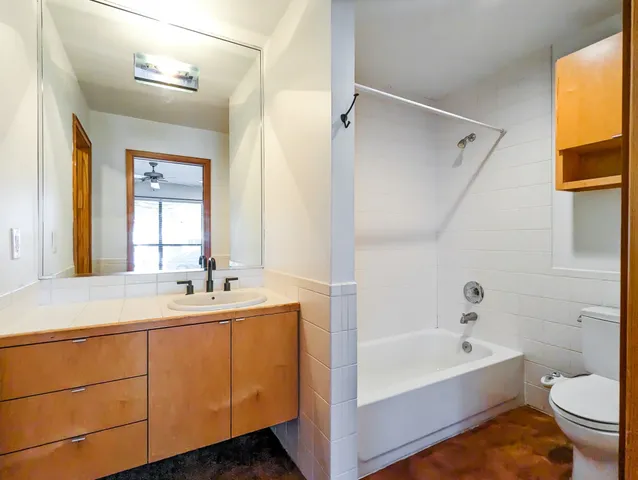 a bathroom with a tub sink toilet and mirror