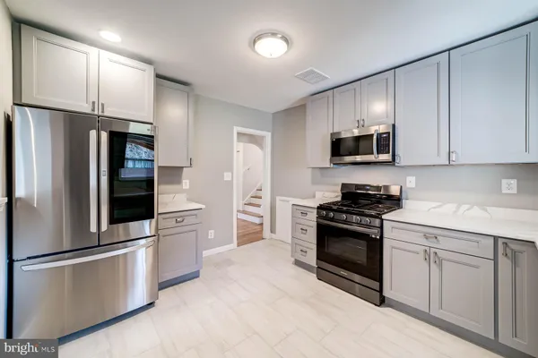 a kitchen with stainless steel appliances granite countertop a stove a refrigerator and a microwave