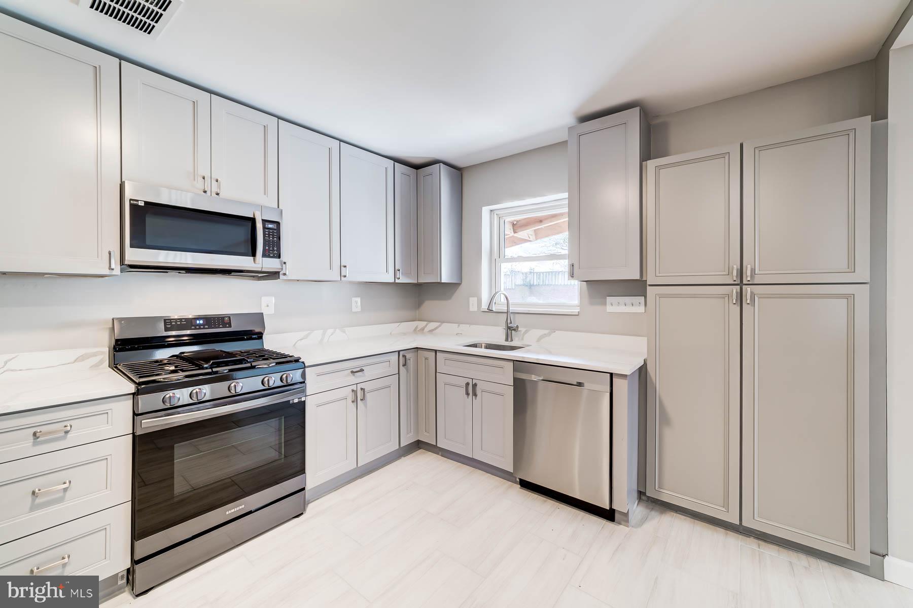 2608 Rittenhouse Street Northwest Washington, DC 20015 - Photo 12 of 45 a kitchen with granite countertop white cabinets and stainless steel appliances