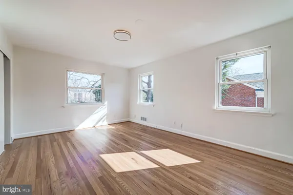 a view of an empty room window and wooden floor