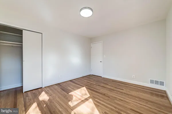 a view of empty room with wooden floor