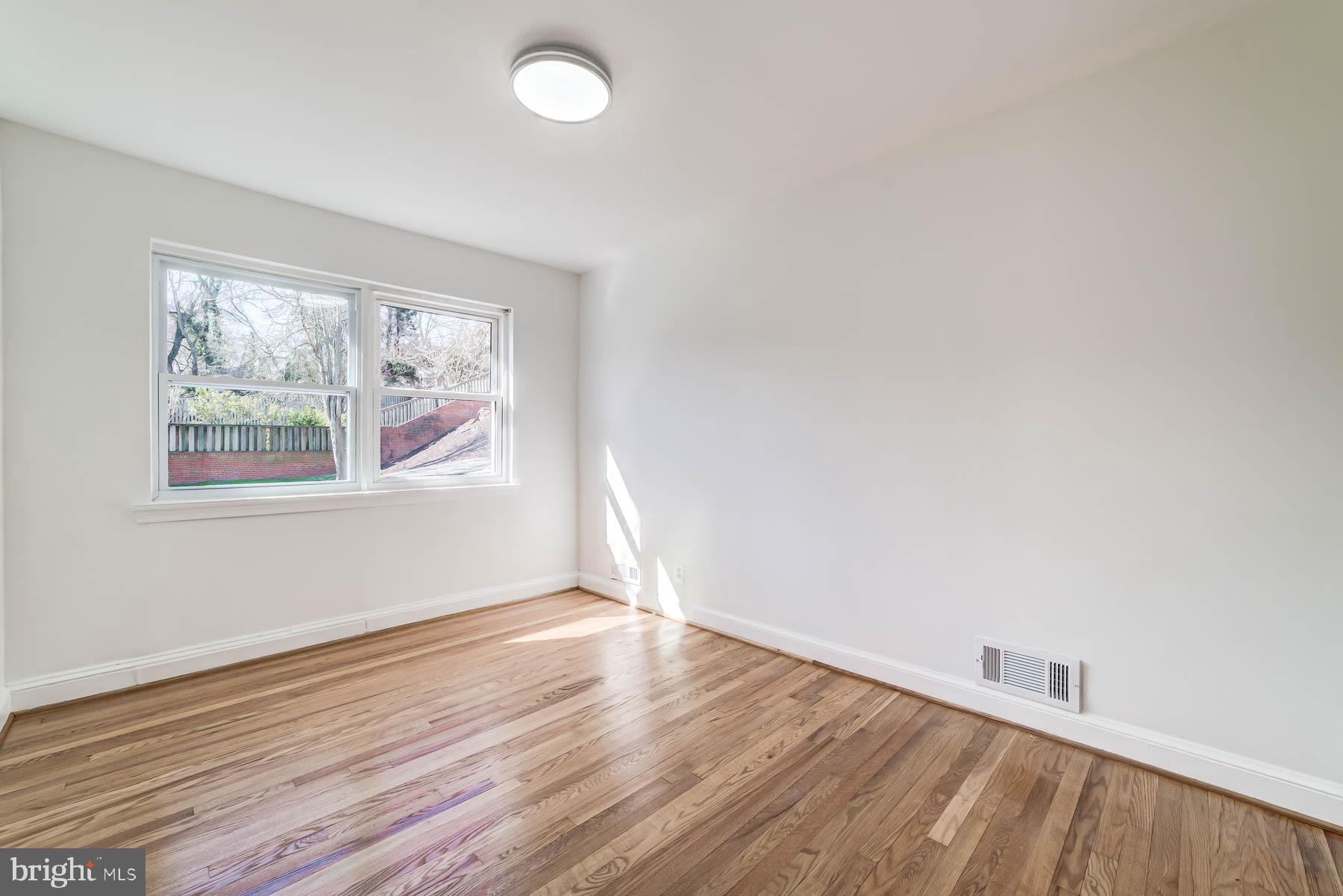 2608 Rittenhouse Street Northwest Washington, DC 20015 - Photo 22 of 45 an empty room with wooden floor and windows